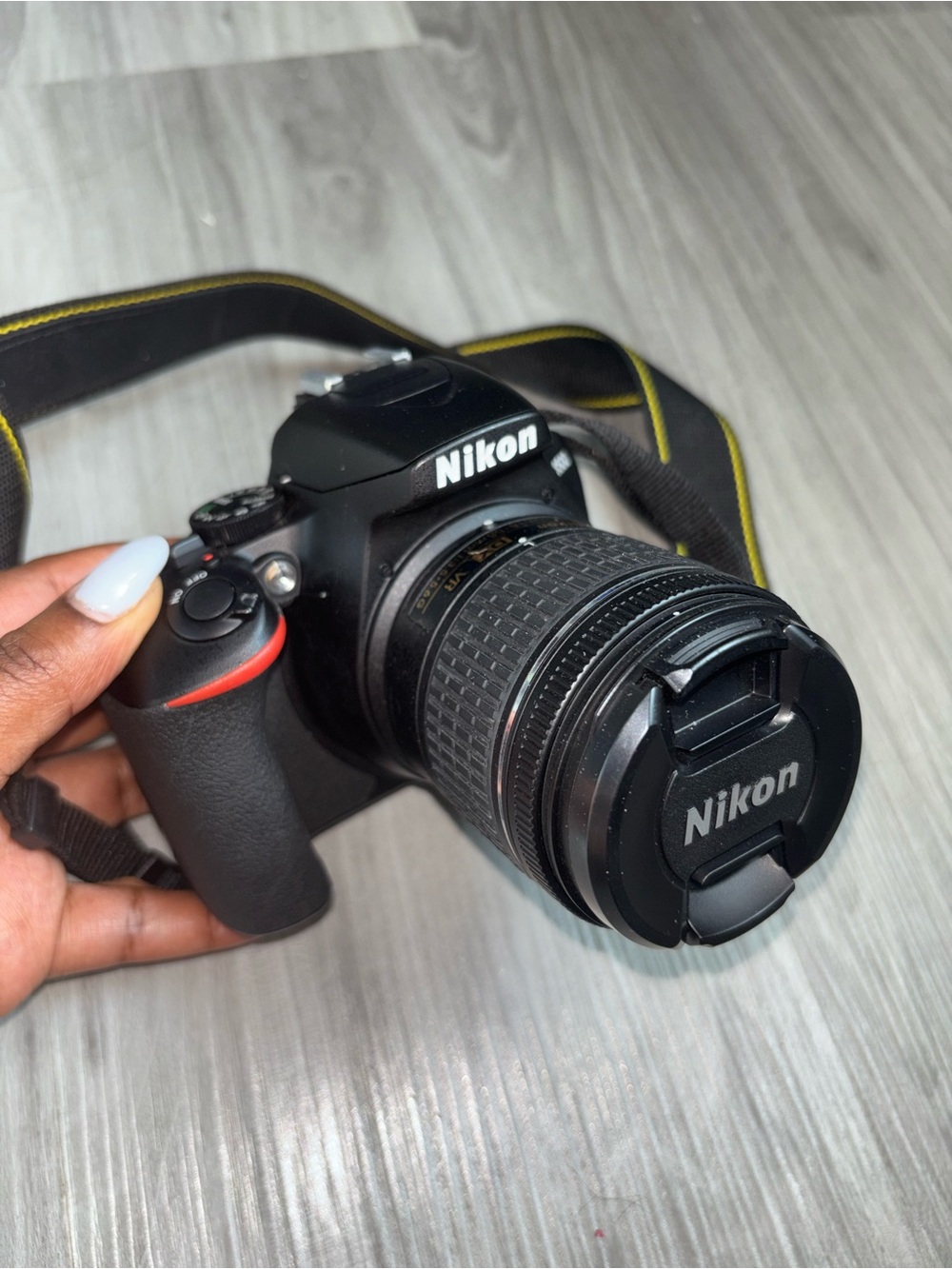 Nikon Black DSLR Camera with Black Zoom Lens and Red Accent